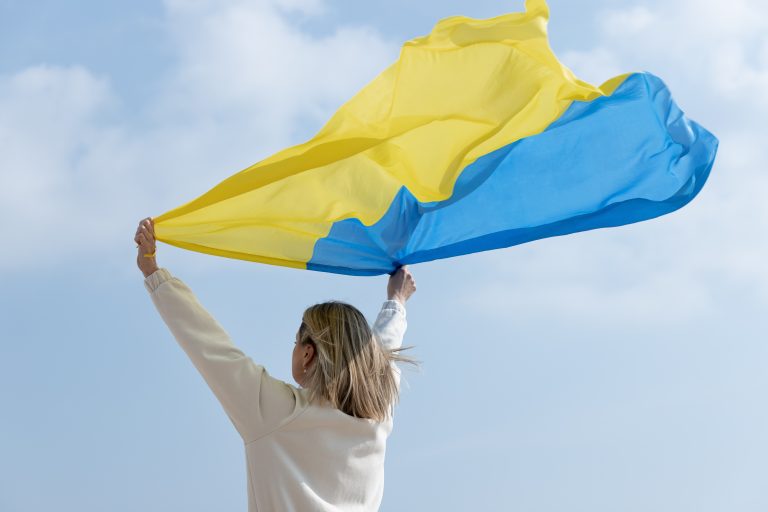 medium-shot-woman-holding-ukranian-flag