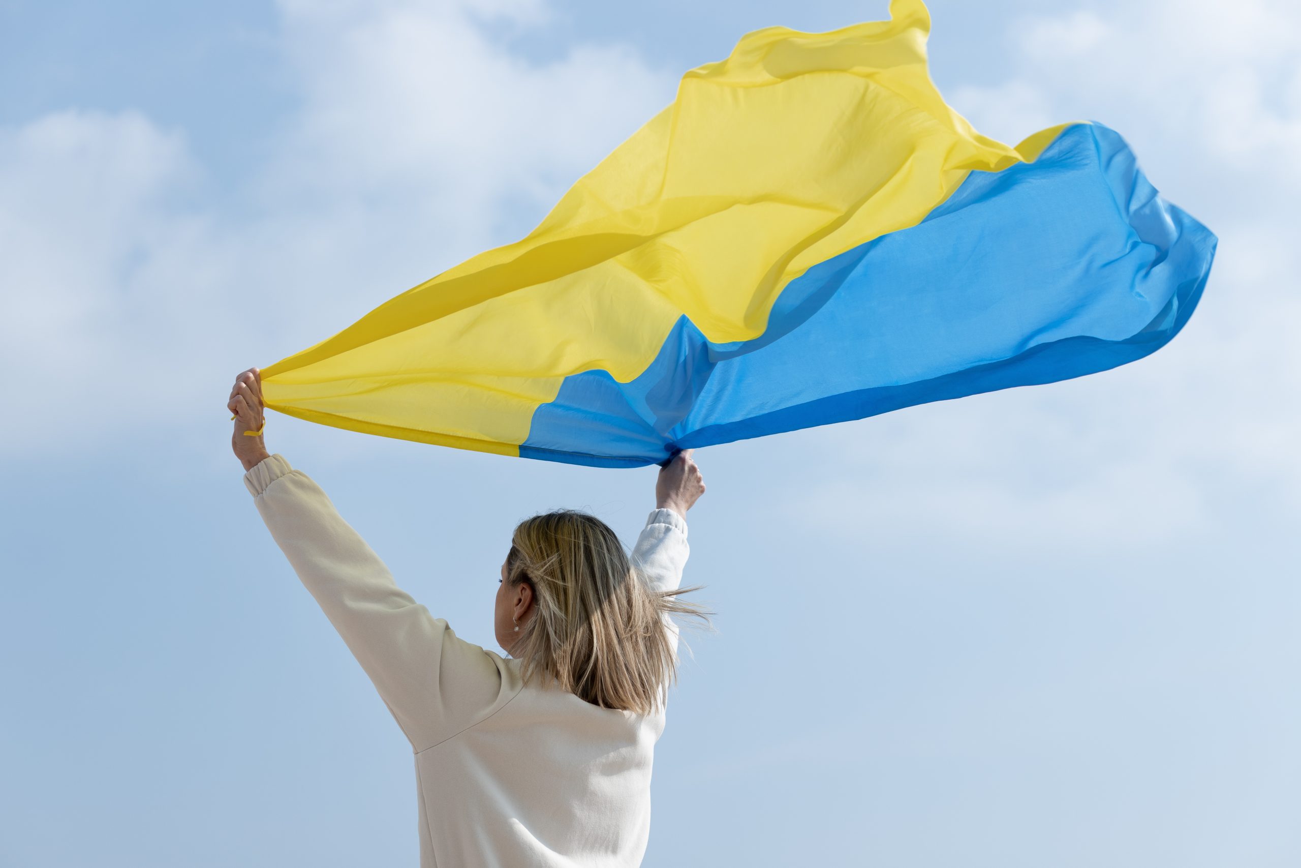 medium-shot-woman-holding-ukranian-flag