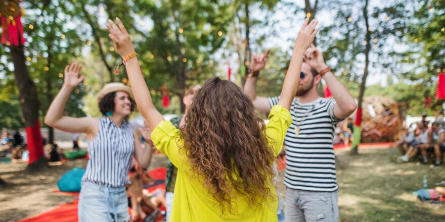 Group of young friends dancing at summer festival.