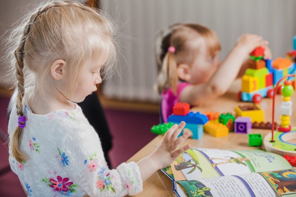 girls-with-book-colorful-toys-1536x1024